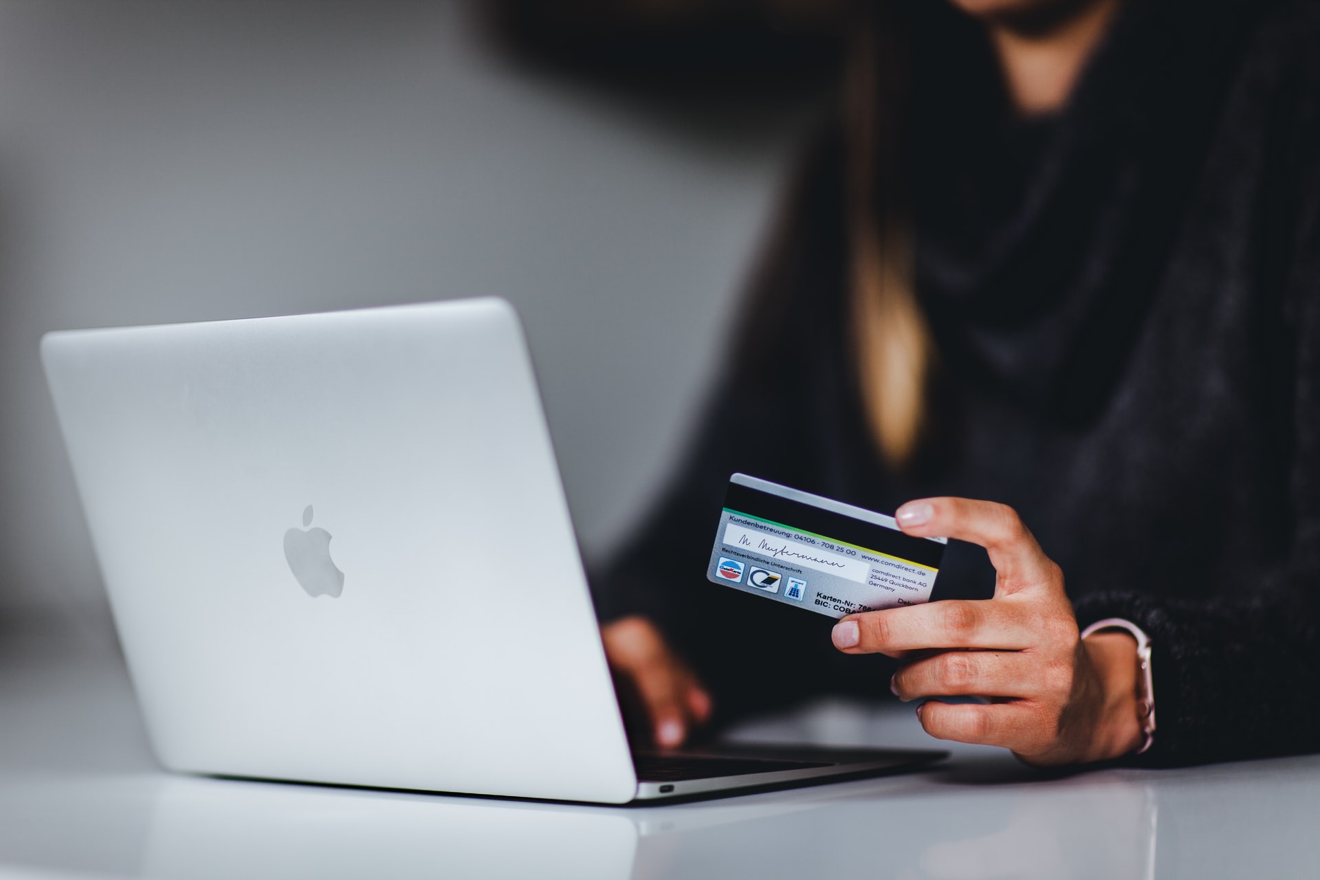 A woman with a latptop and bank card.